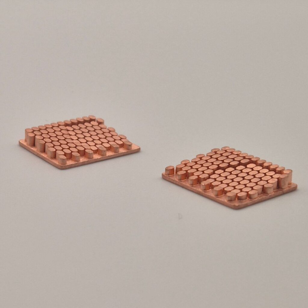 Showcase of two grid-like copper castings with cylindrical elements, highlighting the warm reddish tone and precise structure of natural copper.