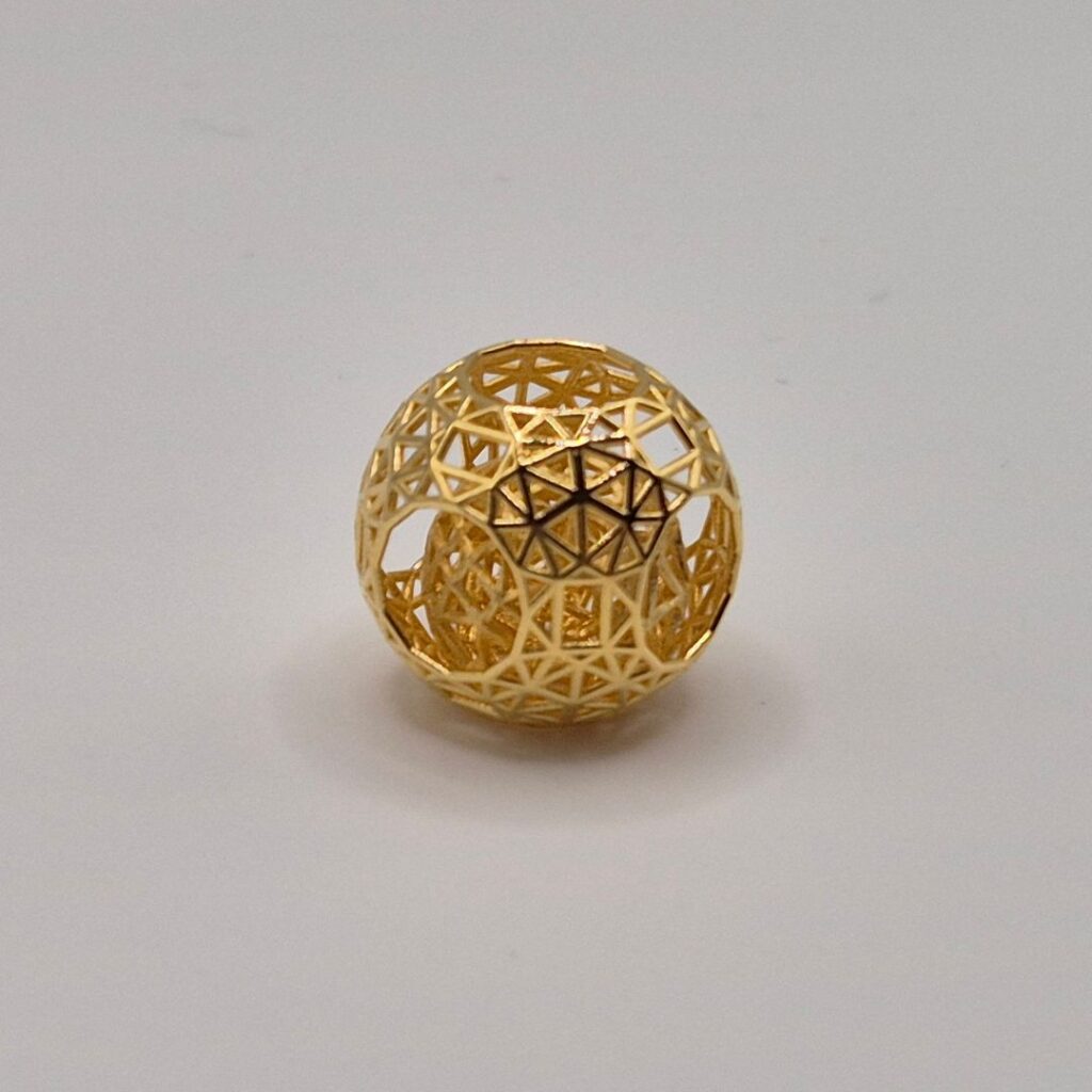 Showcase of a gold cast geometric sphere in 18 carat yellow gold.