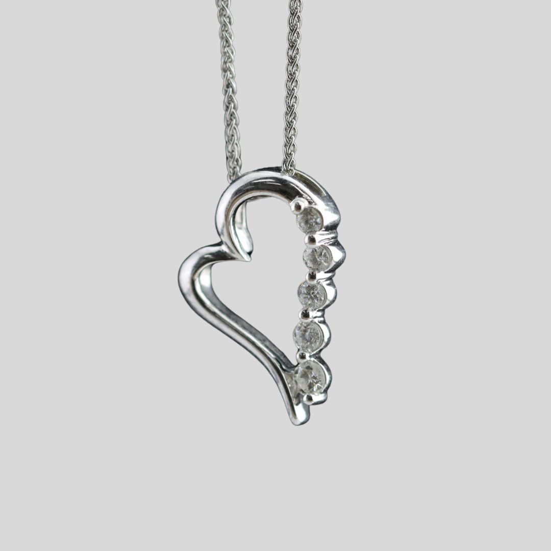 White gold heart-shaped pendant with embedded gemstones.